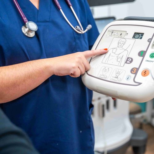 a-cardiologist-explaining-how-a-small-defibrillato a-cardiologist-explaining-how-a-small-defibrillato