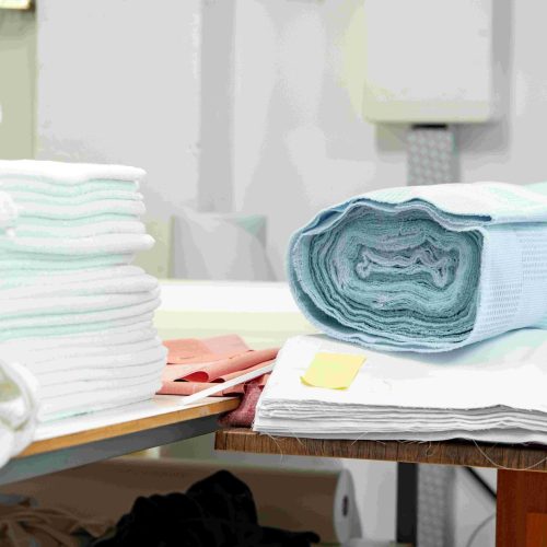 folded-and-rolled-fabrics-on-wooden-shelf-in-tailo folded-and-rolled-fabrics-on-wooden-shelf-in-tailo