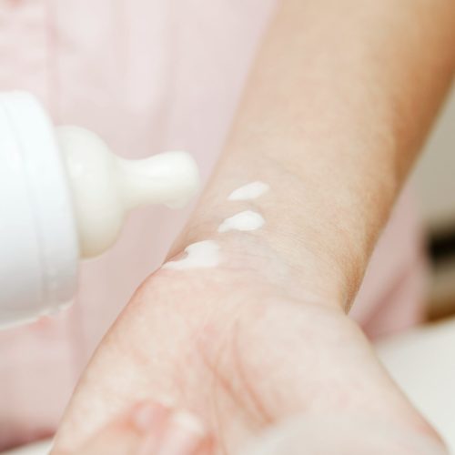 mother-testing-baby-milk-on-wrist-min mother-testing-baby-milk-on-wrist-min