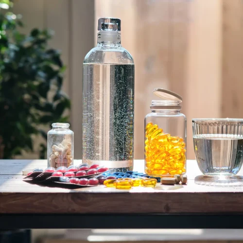 water-bottle-on-a-wooden-table-with-a-set-of-vitam water-bottle-on-a-wooden-table-with-a-set-of-vitam